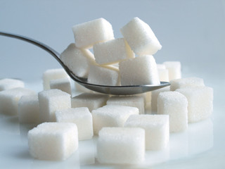 sugar cubes spoonfull over white background