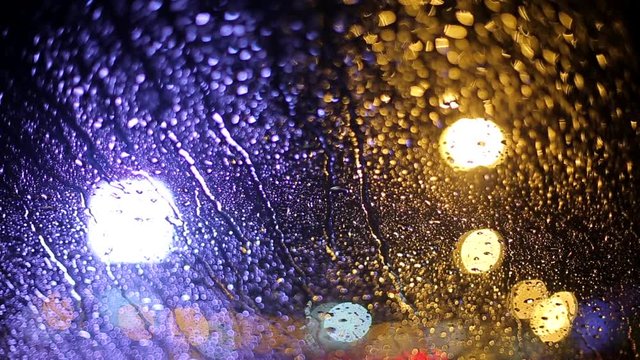 raindrops on a car windshield in the evening lights of the city