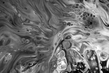 
Abstract black and white background of mixed colors. The spread of paint on the surface. Colorful wallpaper for design