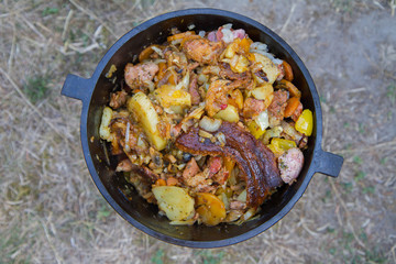 Traditional one pot dish of meat and vegetable done in a cast iron cauldron over a bonfire