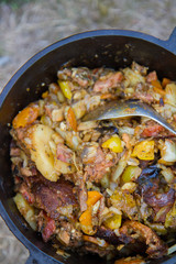 Traditional one pot dish of meat and vegetable done in a cast iron cauldron over a bonfire