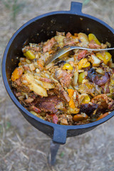 Traditional one pot dish of meat and vegetable done in a cast iron cauldron over a bonfire