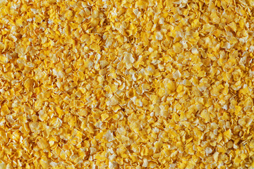 Corn flakes background. Yellow instant corn flakes. Vitamin A concept. View from above. The view is large.