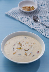 Kheer or Payasam is a type of rice pudding from the Indian subcontinent, made by boiling milk and sugar and is flavoured with dry fruits and nuts, served in ceramic bowl.