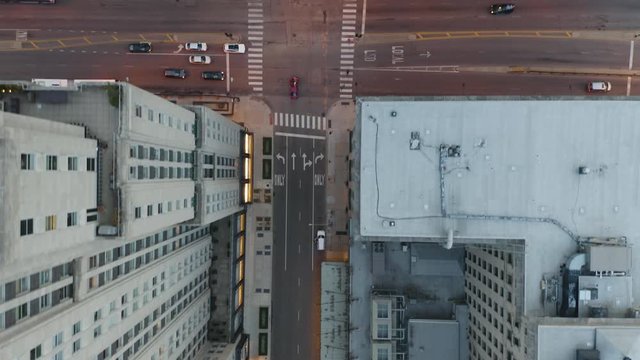 Aerial, Red Car Crosses Urban Intersection with Skyscrapers in Frame
