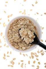 Oat flakes, uncooked oats in bowl with poon and wheat ears on white background. Concept of healthy eating, vegan food, healthy food, breakfast.