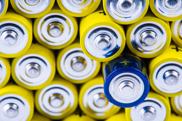 Pile of alkaline batteries size aaa with selection focus on single one