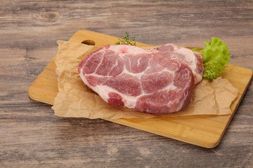 Raw pork steak over wooden board