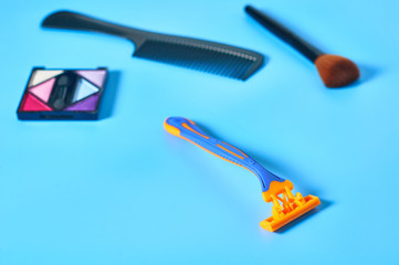 Disposable female razor for depilation and cosmetic accessories on blue background. Care for skin. Beauty concept