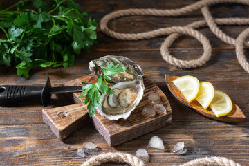 Two oysters on a wooden Board against the background of a basket of oysters. Original restaurant serving of oysters. Rustic style. French cuisine