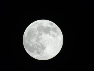 An amazing photography of the full moon over the city of Genova by night with a great clear sky in background and some stars