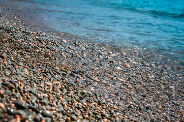 Seascape background colorful stone beach with sea wave