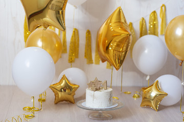 Golden balls in the form of stars with a birthday cake
