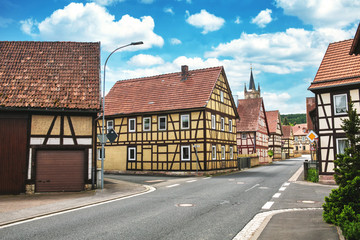 Fototapeta na wymiar view of small viillage with half-timbered houses and cloudy blue sky
