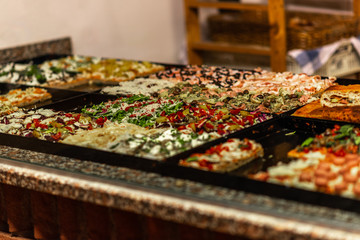A square Italian pizza on the counter in the bistro