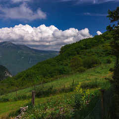 Fototapeta na wymiar A View of the grassy hills at the Lago di Garda area. Significant clouds.