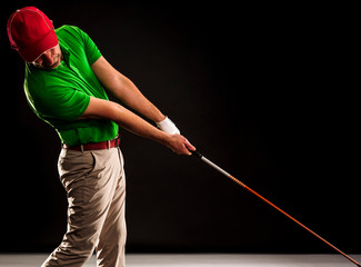 Portrait of a golf player hitting the perfect golf shot isolated on dark background, banner image