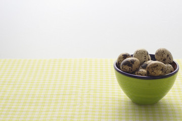 Quail eggs in a green bowl.