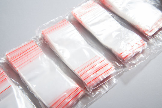 Lot of zipper storage bags, slider storage bags ob grey background in woman habd