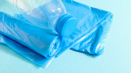 One roll of plastic trash bags in blue on a blue background. Bags that are designed to accommodate garbage in them and used at home and placed in various garbage containers. Copy space