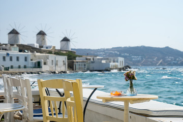 A beautiful view from the small coastal restaurant on white windmills of Mykonos Island. Greece