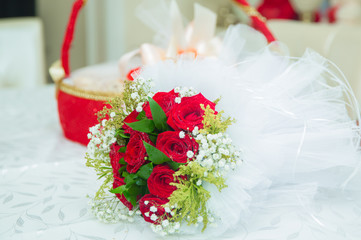 There are drops of water on the roses . Wedding bouquet of red flowers.