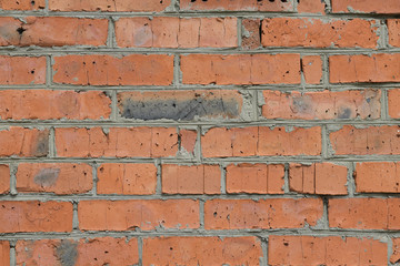 Unique texture of a stone wall made of uneven old bricks and cement