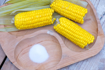 Boiled corn on wooden plate
