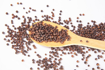 natural organic black pepper in wooden spoon