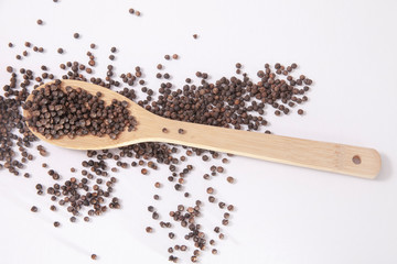 natural organic black pepper in wooden spoon