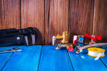 Plumbing supplies and tools on a blue wooden boards closeup