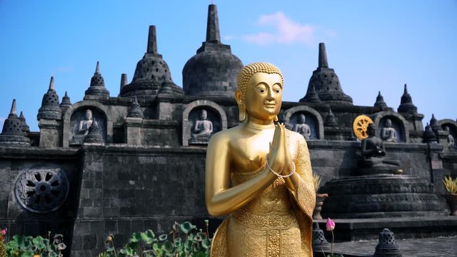 golden buddha in front of indonesian temple in 4k