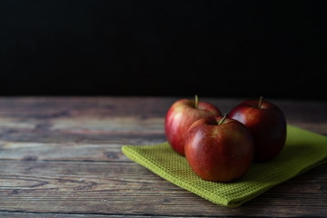 Red apple on the green cloth on the wooden table image