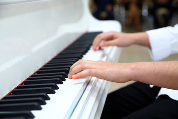 Little boy playing the piano at home . White piano . Azerbaijan Baku 21.02.2020 .
