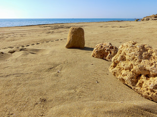 Summer beach with distant sea and footprints on the sand
