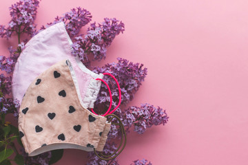 Choose reusable textile face mask. Reusable face mask with lilac flowers on pink background flat lay. Handmade textile face mask. Zero waste lifestyle during coronavirus outbreak