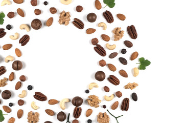 A pattern of nuts on a white background, decorated with green leaves. View to the top, There is a place for inscription. Isolated objects.