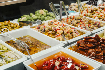 Assortment of olives, pickles and salads on market stand