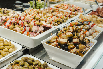 Assortment of olives, pickles and salads on market stand