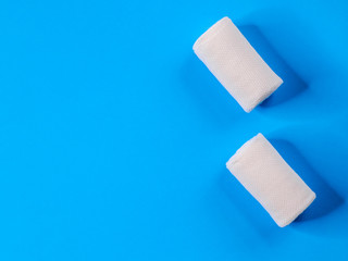 Two medical bandages on a blue background with place for text. Close-up and top view.