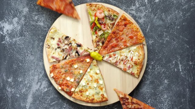 two female hands take in turn slices of pizza from a spinning tray