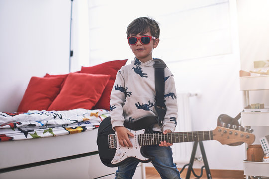 Boy Play Electric Guitar And Learns  
