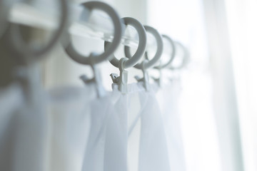 White curtains on the cornice rings.