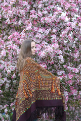 Russian fashionable girl in vintage Pavlovo Posad shawl. Pink flowers of blossoming apple-tree,...