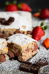 Fototapeta na wymiar Selective focus. Strawberry chocolate cake on a dark background with fresh strawberries