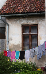 Laundry hanging in front of window of an old ancient house