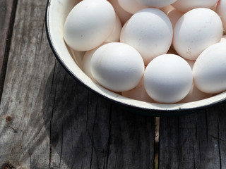 Fresh organic chicken eggs in a metal enamel bowl