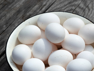 Fresh organic chicken eggs in a metal enamel bowl