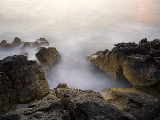 Sunset and waves crashing on the rocks