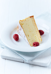 Piece of cheese cake on bright background. Bright wooden background.